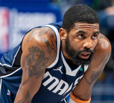 Kyrie Irving leans forward on the court while free throws are attempted during the Dallas Mavericks’ game against the Golden State Warriors at American Airlines Center NBA