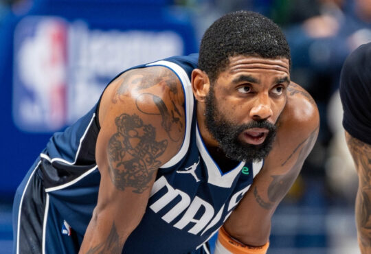 Kyrie Irving leans forward on the court while free throws are attempted during the Dallas Mavericks’ game against the Golden State Warriors at American Airlines Center NBA