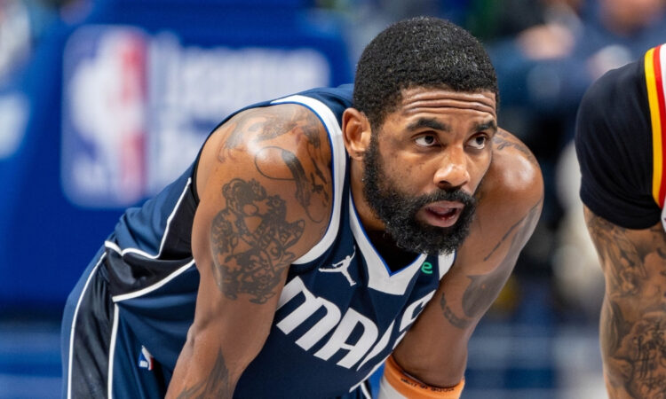 Kyrie Irving leans forward on the court while free throws are attempted during the Dallas Mavericks’ game against the Golden State Warriors at American Airlines Center NBA