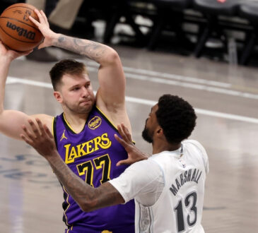 Luka Dončić looks to pass for the Los Angeles Lakers as Naji Marshall defends for the Dallas Mavericks during the fourth quarter at American Airlines Center