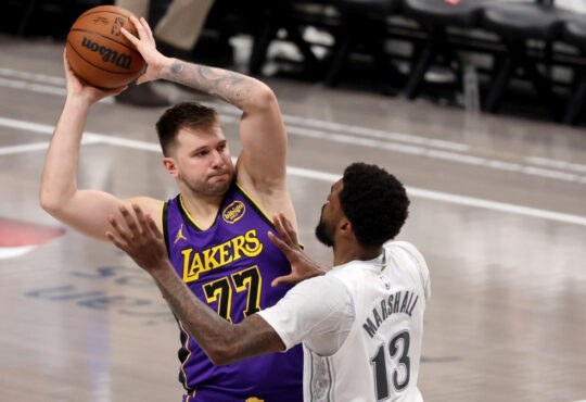 Luka Dončić looks to pass for the Los Angeles Lakers as Naji Marshall defends for the Dallas Mavericks during the fourth quarter at American Airlines Center