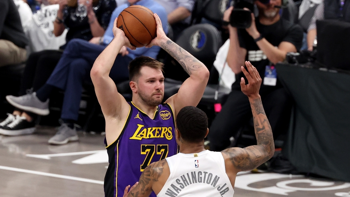 Luka Dončić looks to pass for the Los Angeles Lakers as P.J. Washington defends for the Dallas Mavericks at American Airlines Center