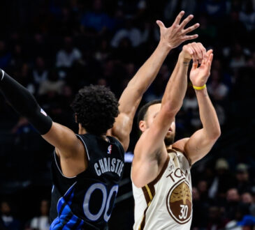 Max Christie contests a three-point attempt by Stephen Curry at American Airlines Center during a game against the Golden State Warriors