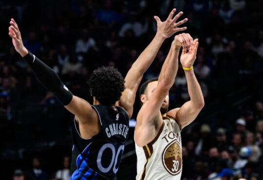 Max Christie contests a three-point attempt by Stephen Curry at American Airlines Center during a game against the Golden State Warriors