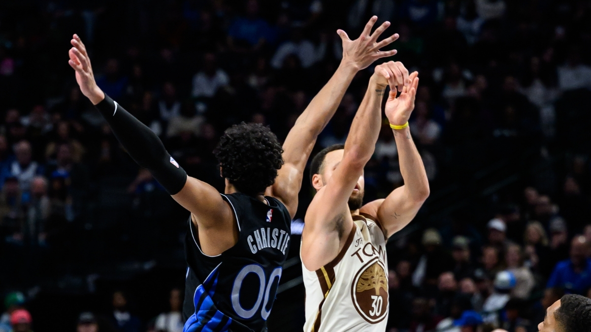 Max Christie contests a three-point attempt by Stephen Curry at American Airlines Center during a game against the Golden State Warriors