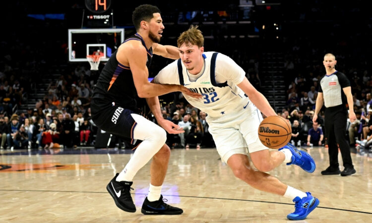 NBA: Cooper Flagg dribbles past Devin Booker during the first half of Mavericks vs. Suns at Mortgage Matchup Center in Phoenix.