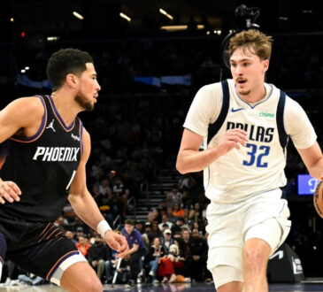NBA: Cooper Flagg dribbles the ball for the Dallas Mavericks while defended by Devin Booker of the Phoenix Suns at Mortgage Matchup Center.