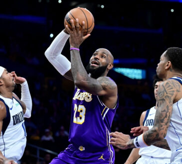 NBA: LeBron James drives to the basket at Crypto.com Arena between Brandon Williams and P.J. Washington during Dallas Mavericks vs. Los Angeles Lakers.