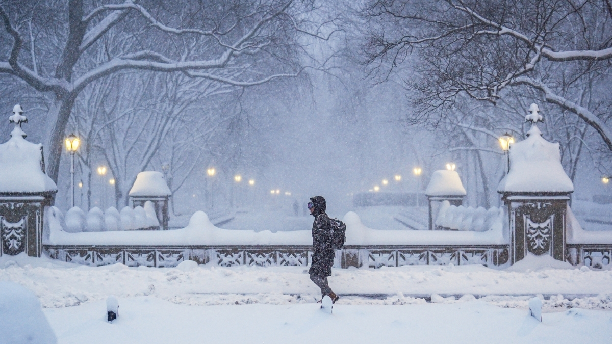 A commuter walks through heavy snowfall in Central Park during a Nor’Easter in New York City.