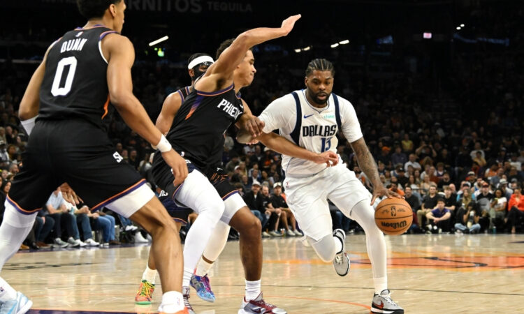 NBA: Naji Marshall brings the ball up court for the Dallas Mavericks while defended by Oso Ighodaro of the Phoenix Suns at Mortgage Matchup Center.