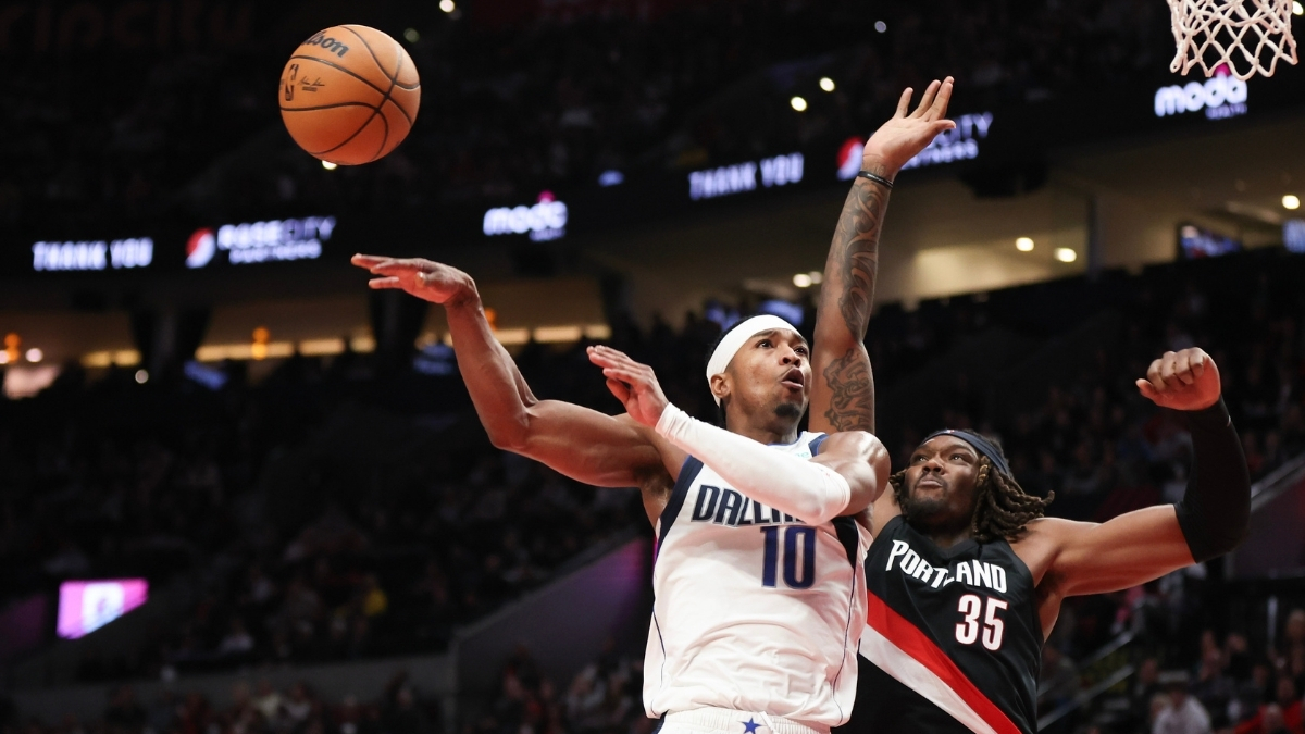 Brandon Williams of the Dallas Mavericks passes away from Robert Williams III of the Portland Trail Blazers during the fourth quarter at Moda Center on December 29, 2025.