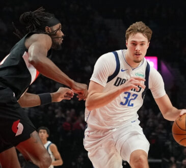 Cooper Flagg #32 of the Dallas Mavericks dribbles against Jerami Grant #9 of the Portland Trail Blazers during a 20-point first half at Moda Center.