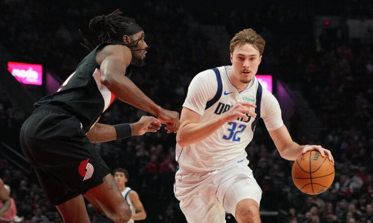 Cooper Flagg #32 of the Dallas Mavericks dribbles against Jerami Grant #9 of the Portland Trail Blazers during a 20-point first half at Moda Center.