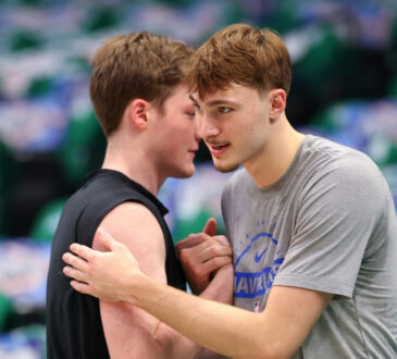Cooper Flagg #32 of the Dallas Mavericks and Kon Knueppel #7 of the Charlotte Hornets embrace on the court at American Airlines Center.