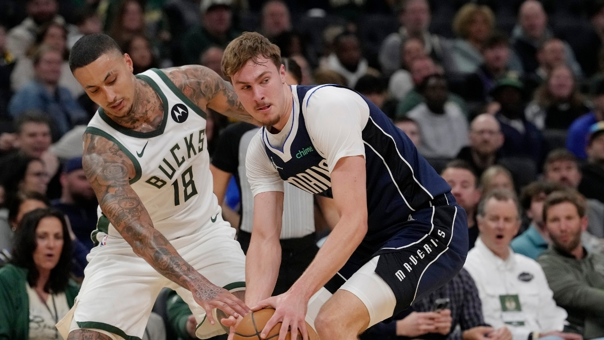 Cooper Flagg #32 of the Dallas Mavericks attempts a steal against Kyle Kuzma #18 of the Milwaukee Bucks during the first quarter at Fiserv Forum.