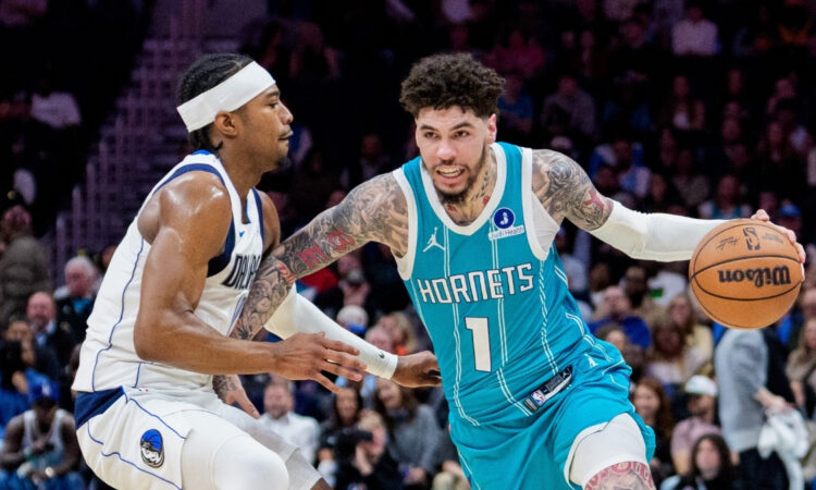 NBA: LaMelo Ball brings the ball up court for the Charlotte Hornets while guarded by Brandon Williams of the Dallas Mavericks during a game at Spectrum Center.