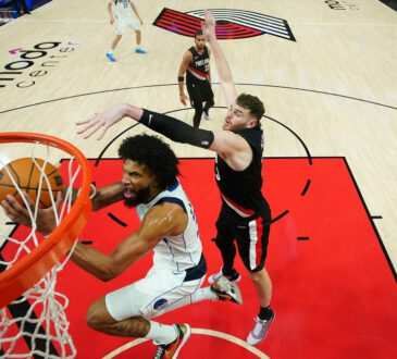 Marvin Bagley III of the Dallas Mavericks attempts a layup defended by Donovan Clingan of the Portland Trail Blazers during the second half at Moda Center on March 27, 2026.