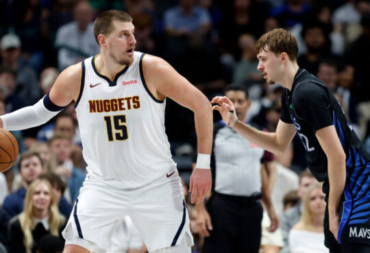 Nikola Jokic of the Denver Nuggets controls the ball while defended by Dallas Mavericks rookie Cooper Flagg during the second half on December 23, 2025 in Dallas.