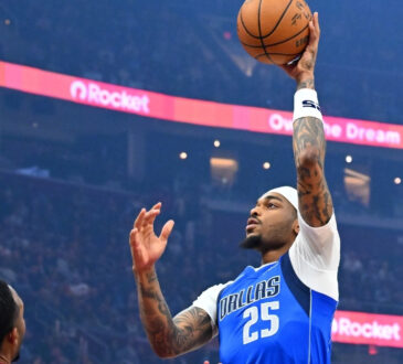 P.J. Washington Jr. #25 of the Dallas Mavericks shoots over Dean Wade #32 and Evan Mobley #4 of the Cleveland Cavaliers during the first quarter at Rocket Arena on March 15, 2026 in Cleveland, Ohio.