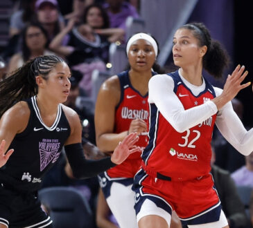 Washington Mystics forward Alysha Clark looks for a passing lane while guarded by Veronica Burton of the Golden State Valkyries.
