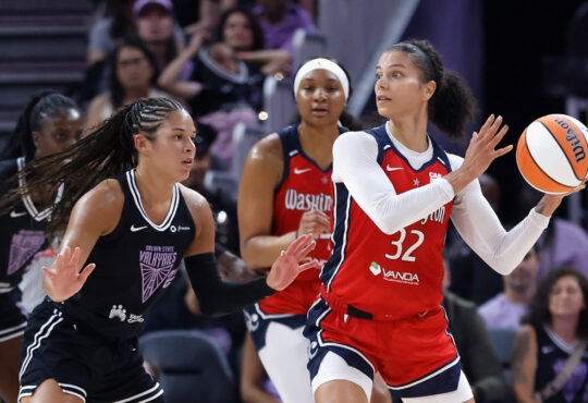 Washington Mystics forward Alysha Clark looks for a passing lane while guarded by Veronica Burton of the Golden State Valkyries.
