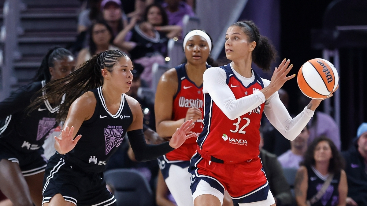 Washington Mystics forward Alysha Clark looks for a passing lane while guarded by Veronica Burton of the Golden State Valkyries.