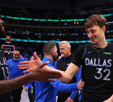 Naji Marshall #13 of the Dallas Mavericks greets Cooper Flagg #32 as they exit the court following a victory over the Los Angeles Lakers at American Airlines Center.