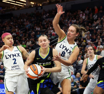 Paige Bueckers of the Dallas Wings drives to the basket against Alanna Smith and Natisha Hiedeman of the Minnesota Lynx.