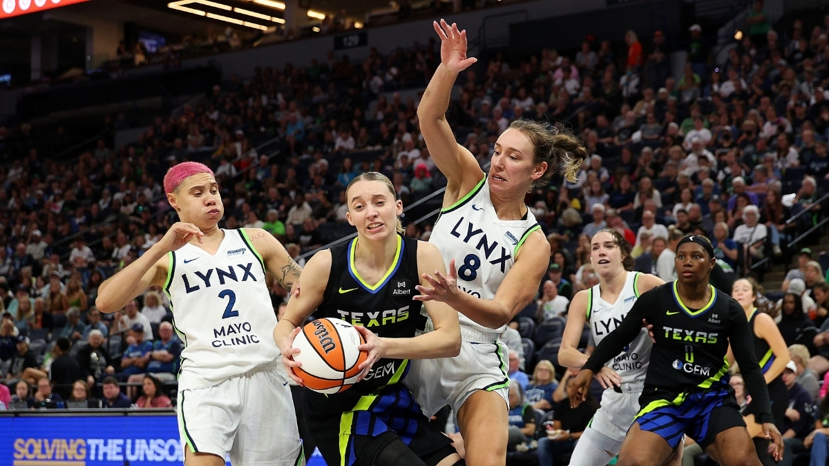 Paige Bueckers of the Dallas Wings drives to the basket against Alanna Smith and Natisha Hiedeman of the Minnesota Lynx.