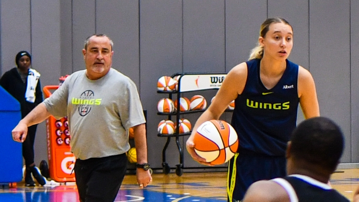 Dallas Wings star Paige Bueckers handles the ball in transition while head coach Jose Fernandez watches from the sideline at College Park Center.