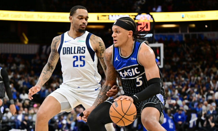 Paolo Banchero of the Orlando Magic dribbles toward the basket while being defended by P.J. Washington of the Dallas Mavericks on March 5, 2026.