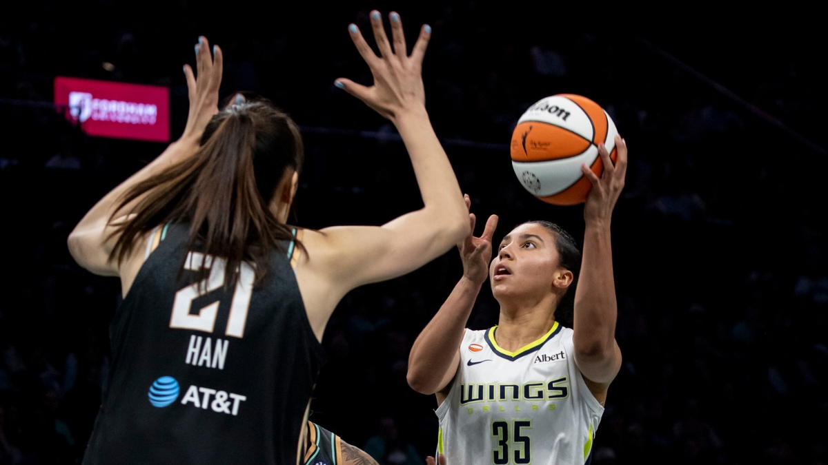 Rookie guard Azzi Fudd releasing a high-arcing jump shot over the contested challenge of center Han Xu.