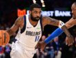 Guard Kyrie Irving wearing a blue Dallas Mavericks jersey while handling the ball on the perimeter against defender Jalen Williams of the Oklahoma City Thunder.
