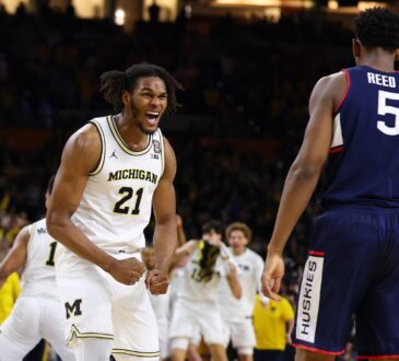 Michigan sophomore big man Morez Johnson Jr. screaming in celebration amidst falling confetti on the court after winning the national title.