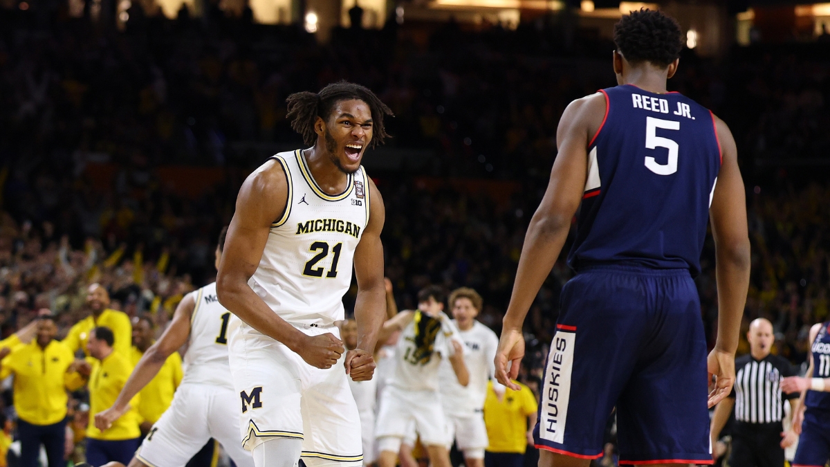 Michigan sophomore big man Morez Johnson Jr. screaming in celebration amidst falling confetti on the court after winning the national title.