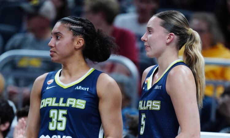 Paige Bueckers and Azzi Fudd watching from the bench during the Mavericks' preseason game against the Indiana Fever.