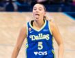 Guard Paige Bueckers celebrating on the court, smiling and gesturing dynamically after a successful offensive sequence.