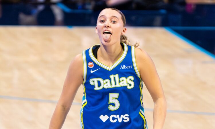 Guard Paige Bueckers celebrating on the court, smiling and gesturing dynamically after a successful offensive sequence.