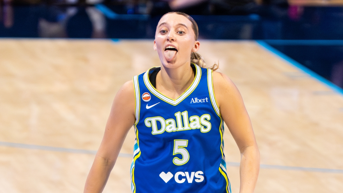 Guard Paige Bueckers celebrating on the court, smiling and gesturing dynamically after a successful offensive sequence.