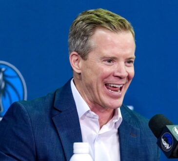 Dusty May smiles while answering questions at the podium during his introductory press conference as Dallas Mavericks head coach.