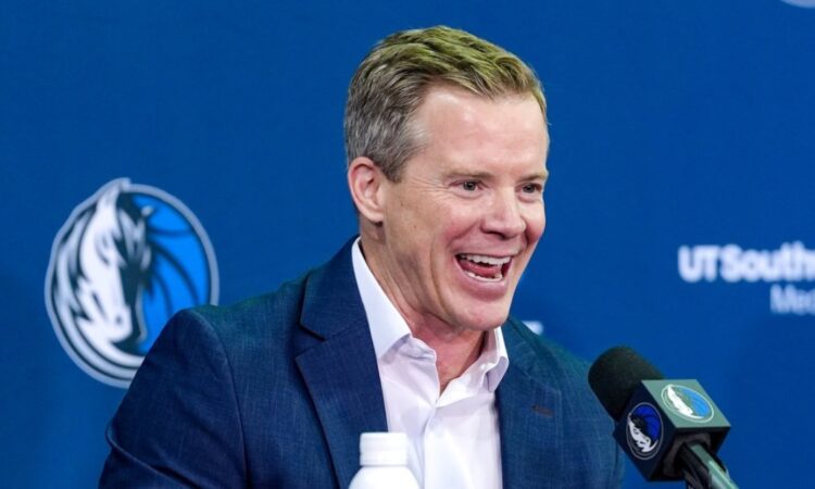 Dusty May smiles while answering questions at the podium during his introductory press conference as Dallas Mavericks head coach.