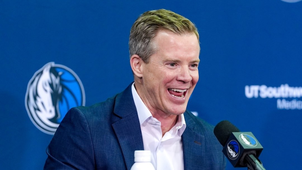 Dusty May smiles while answering questions at the podium during his introductory press conference as Dallas Mavericks head coach.