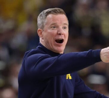 Michigan coach Dusty May shouts and points from the sideline during a game.