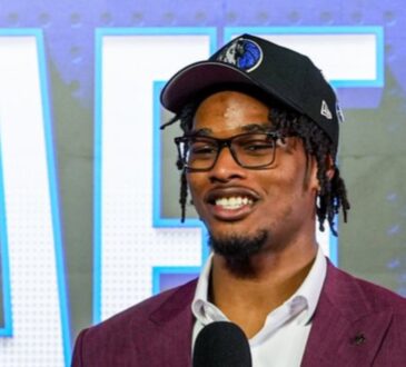 Morez Johnson Jr. smiles in a Dallas Mavericks cap and maroon suit while speaking on stage after being drafted No. 9 in the 2026 NBA Draft