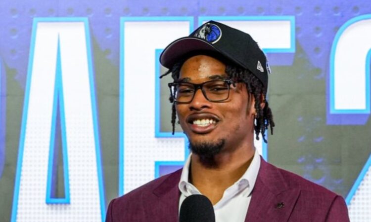 Morez Johnson Jr. smiles in a Dallas Mavericks cap and maroon suit while speaking on stage after being drafted No. 9 in the 2026 NBA Draft