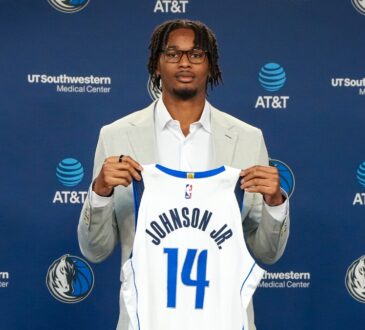 Morez Johnson Jr. holds his No. 14 Dallas Mavericks jersey at his introductory press conference