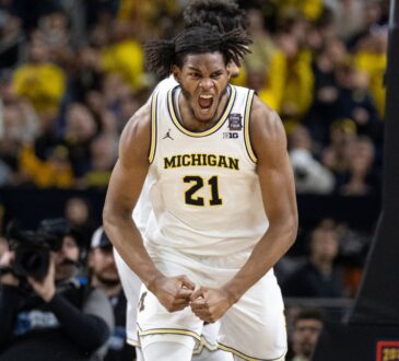 Morez Johnson Jr. flexes and celebrates in a white Michigan No. 21 jersey during the 2026 NCAA national championship game against UConn