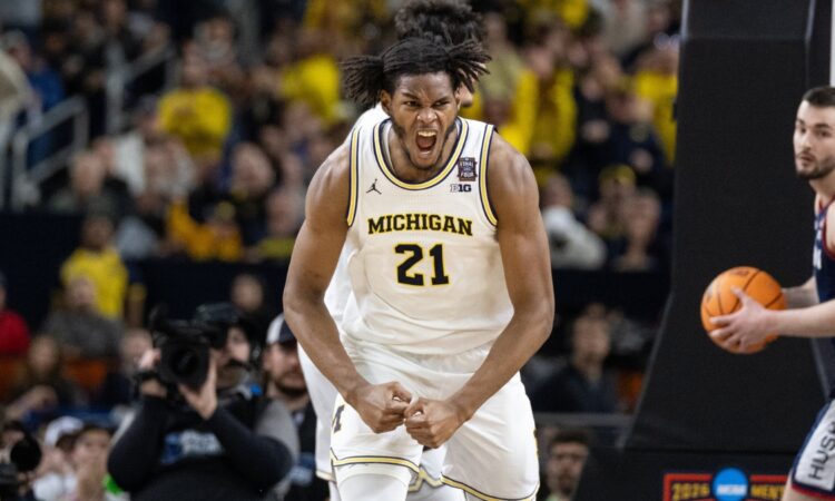 Morez Johnson Jr. flexes and celebrates in a white Michigan No. 21 jersey during the 2026 NCAA national championship game against UConn