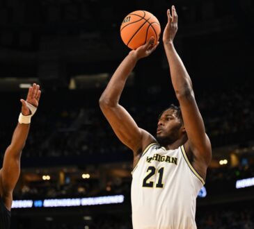 Morez Johnson Jr. rises for a jump shot in a white Michigan No. 21 jersey over a Howard defender during the 2026 NCAA Tournament