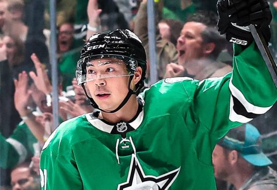 Dallas Stars forward Jason Robertson raises his stick to celebrate a goal in front of fans at American Airlines Center